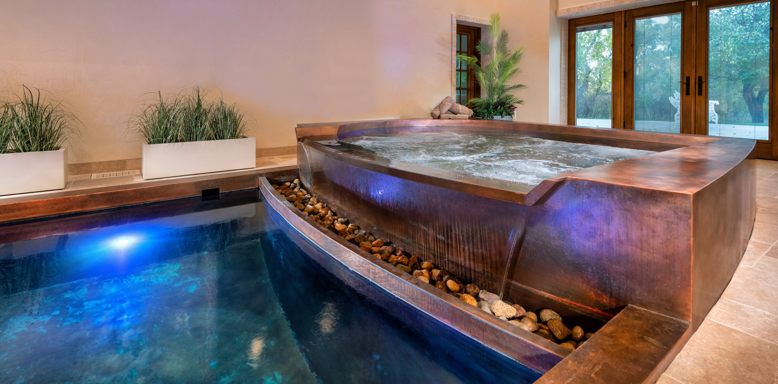 Copper pool and spa. The pool has an interior descending stairway and two underwater hydraulic treadmills with swim jet systems and LED lighting. The spa has LED lighting, front spill over water feature, two loungers and bench seating. 133