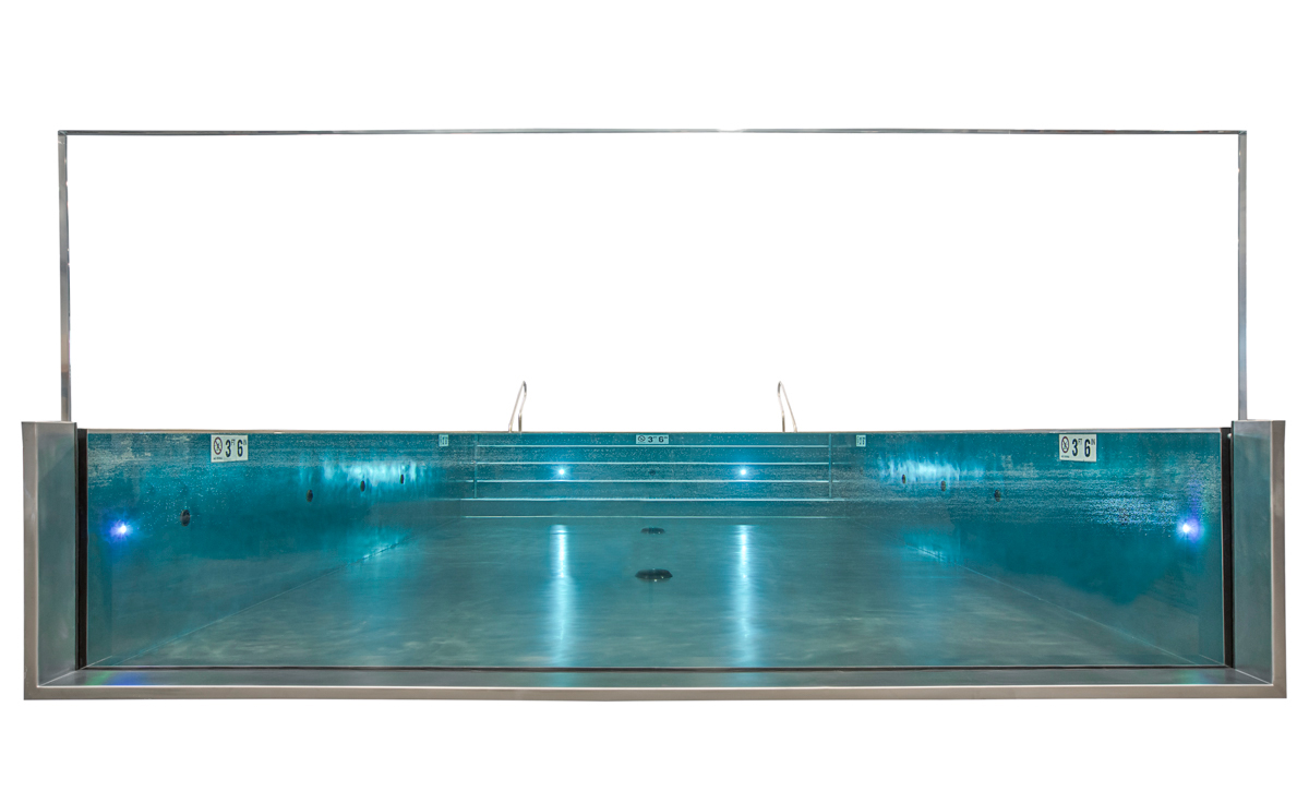 Stainless steel rooftop commercial pool with LED lighting, tiled interior stairway, three-sided infinity edge descending into catch basin and acrylic wall at end of pool. 223”x376”x53”.  Glass panel 223”x 101” tall.